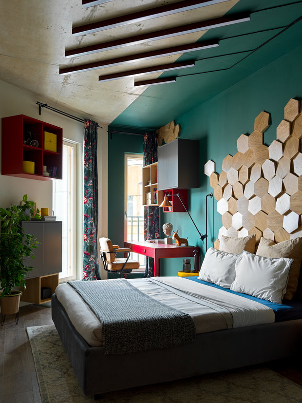 В спальне хозяйки квартиры использовали мозаику из деревянных гексагонов в изголовье кровати, а также частичную покраску стены и потолка в глубокий зеленый оттенок. 