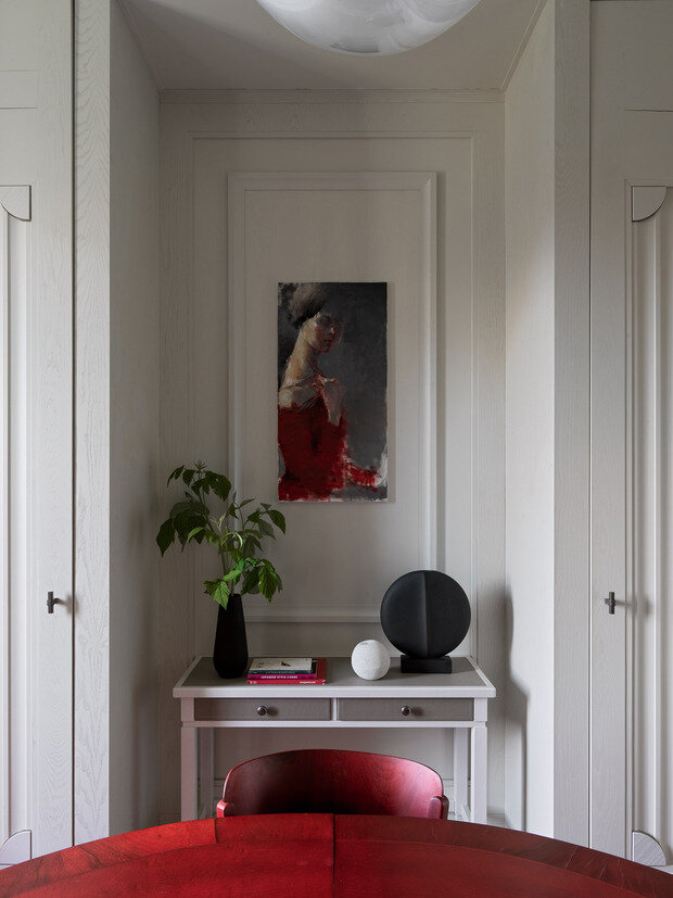 Консоль с кожаной отделкой выполнена по эскизам дизайнера. Над ней — картина художницы Ольги Мороз, на которой изображена хозяйка квартиры.